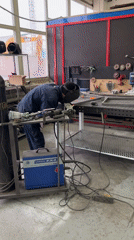 Worker welds BBQ smoker construction in Chaikovsky workshop