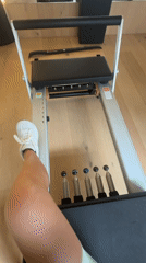 Person exercises on Pilates reformer in Barcelona fitness studio