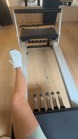 Person exercises on Pilates reformer in Barcelona fitness studio