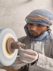 Traditional stone craftsmen work grinding wheels in Kandahar workshops