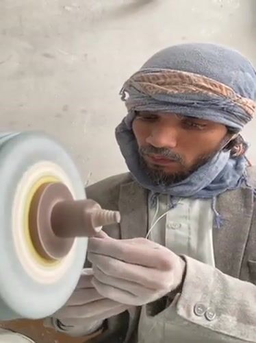 Traditional stone craftsmen work grinding wheels in Kandahar workshops