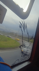 Bus passenger captures road view through decorated window in Quito