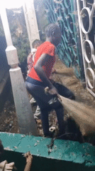 Two people sweep insects from streetlight in Jos, Nigeria