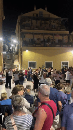 Evening crowd fills a town square in Cupra Marittima