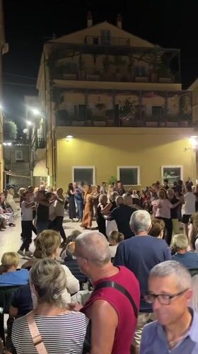 Evening crowd fills a town square in Cupra Marittima
