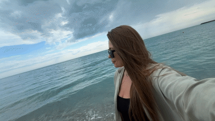Woman takes selfie on beach in Olginka, Russia