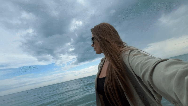 Woman takes selfie on beach in Olginka, Russia