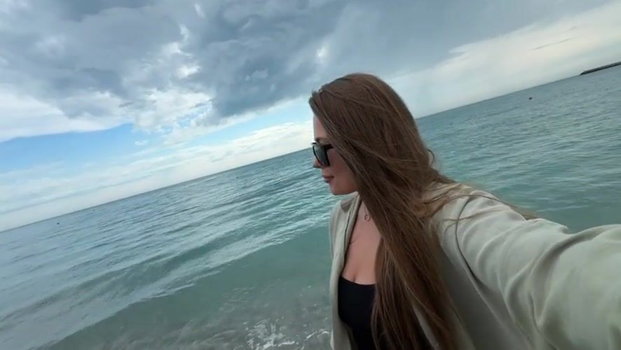 Woman takes selfie on beach in Olginka, Russia