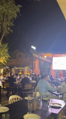 Outdoor crowd gathers at night to watch live soccer