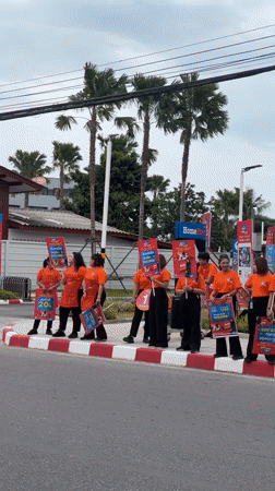Street promo crew with signs works a Ko Samui sidewalk