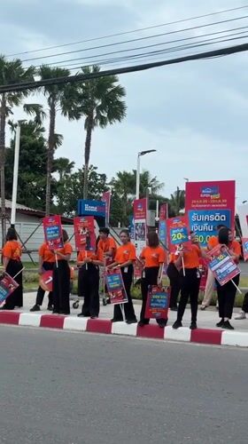 Street promo crew with signs works a Ko Samui sidewalk