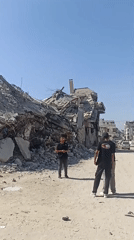 Excavators clear rubble across a destroyed Gaza street