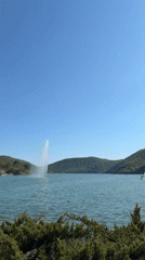 Visitors gather at Lake Abrau fountain on sunny afternoon