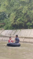 Boys enjoy river tubing in Saweuk, Indonesia