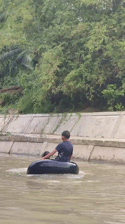Boys enjoy river tubing in Saweuk, Indonesia