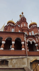 Woman poses with dog near Orthodox cathedral in Izhevsk