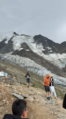 Hikers pause on a rocky path with glacier views above Saint-Gervais