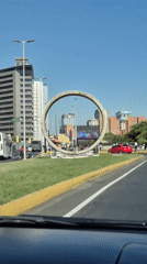 Evening rush hour traffic flows past monument in Caracas
