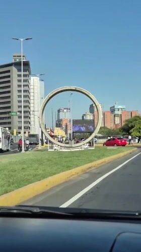Evening rush hour traffic flows past monument in Caracas