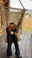 Person relaxes in swing chair on porch in Tyulyuk