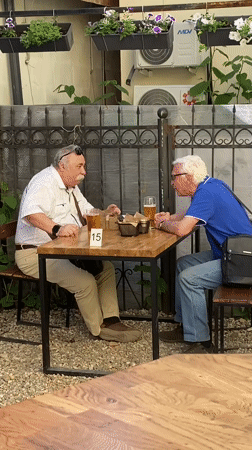 Men share beer at decorated outdoor patio in Zavolzhye