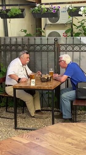 Men share beer at decorated outdoor patio in Zavolzhye