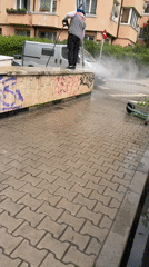 Worker cleans graffiti near blooming gate entrance in Sofia