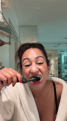 Woman brushes teeth in Los Angeles bathroom Tuesday evening