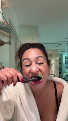 Woman brushes teeth in Los Angeles bathroom Tuesday evening