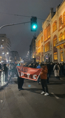 Nighttime crowd gathers for protest in Belgrade, media interviews conducted