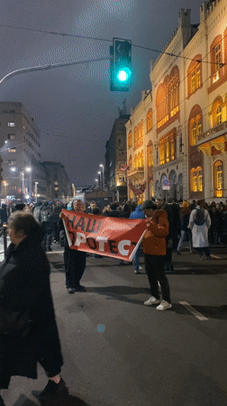 Nighttime crowd gathers for protest in Belgrade, media interviews conducted