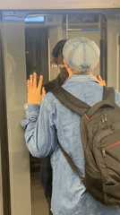Man with backpack stands against train door in Moscow