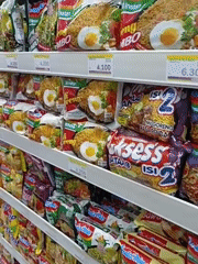 Inside a stocked Indonesian convenience store, snacks and bread on shelves