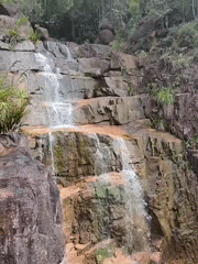 Tiered waterfall and Buddha statue in a Vietnamese forest