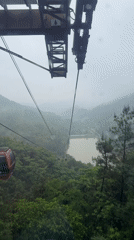 Cable car ascends through foggy mountains in Yongding District