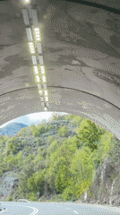 Car exits lit tunnel on Montenegro hillside road