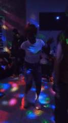 Dance floor energy at a small disco-lit indoor party