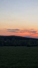Rural sunset documented across green fields and village houses