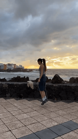 Woman jump ropes on seaside walkway during sunset in Puerto de la Cruz