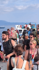 Ferry passengers board and disembark at Indonesian pier