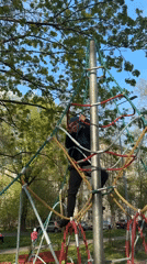Child climbs colorful rope playground structure in Saint Petersburg park