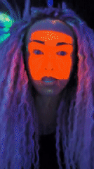 Person applies glowing face paint under blacklights in Noviy