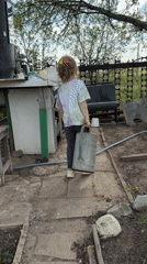 Child gardens with dog in Kamyshin backyard