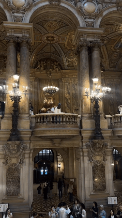 Visitors explore ornate Palais Garnier opera house interior in Paris