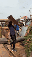Workers load scrap metal at Nigerian recycling facility
