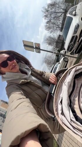 Woman takes selfie with baby in stroller in Vitenyovo