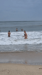Overcast beach day in Đà Nẵng, waves and shoreline activity