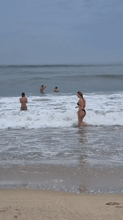 Overcast beach day in Đà Nẵng, waves and shoreline activity