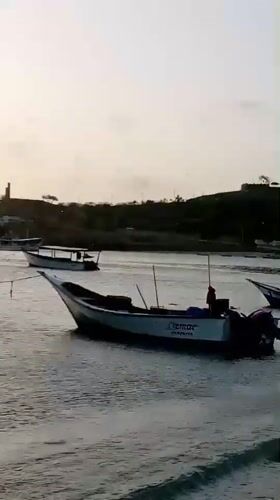 Sunset observed over Juan Griego harbor with fishing boats