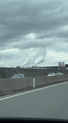 Motorist films industrial smokestacks from highway near Wals, Austria